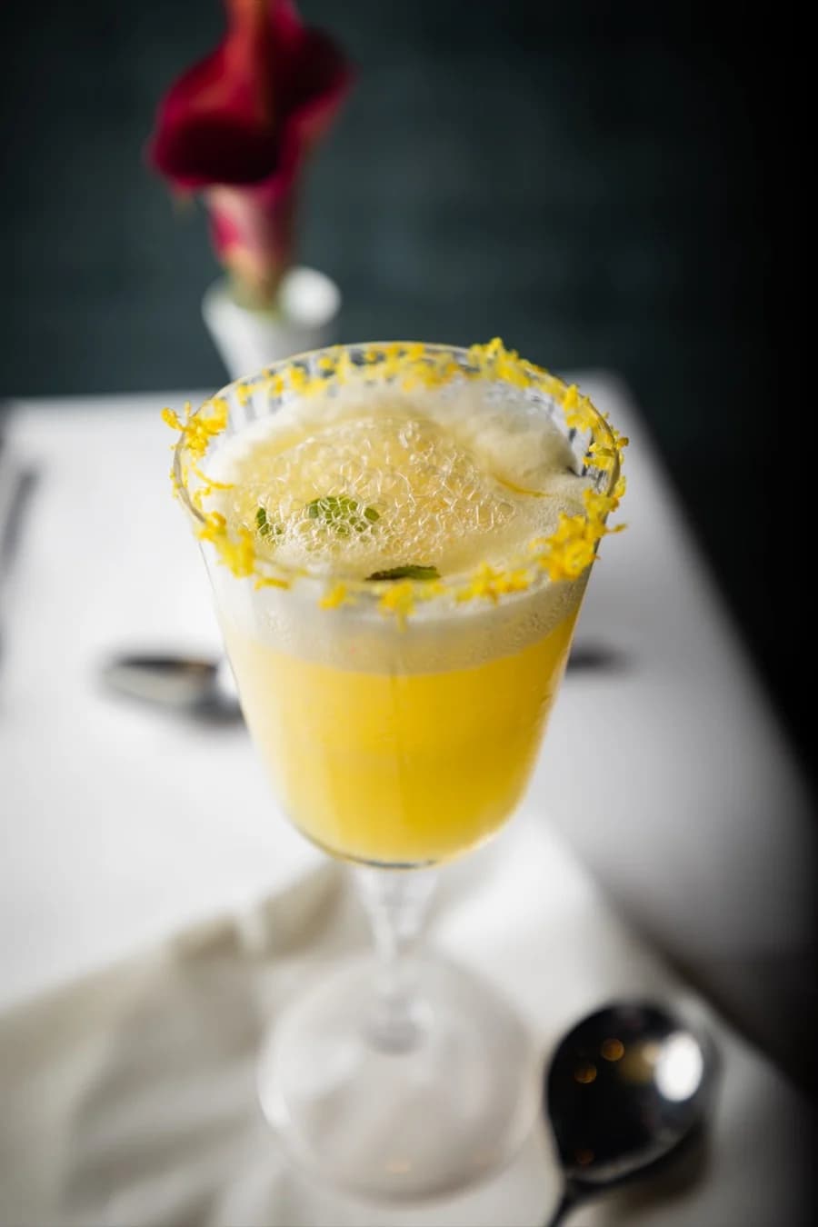 Gelber Cocktail mit Schaumkrone und Zuckerrand
