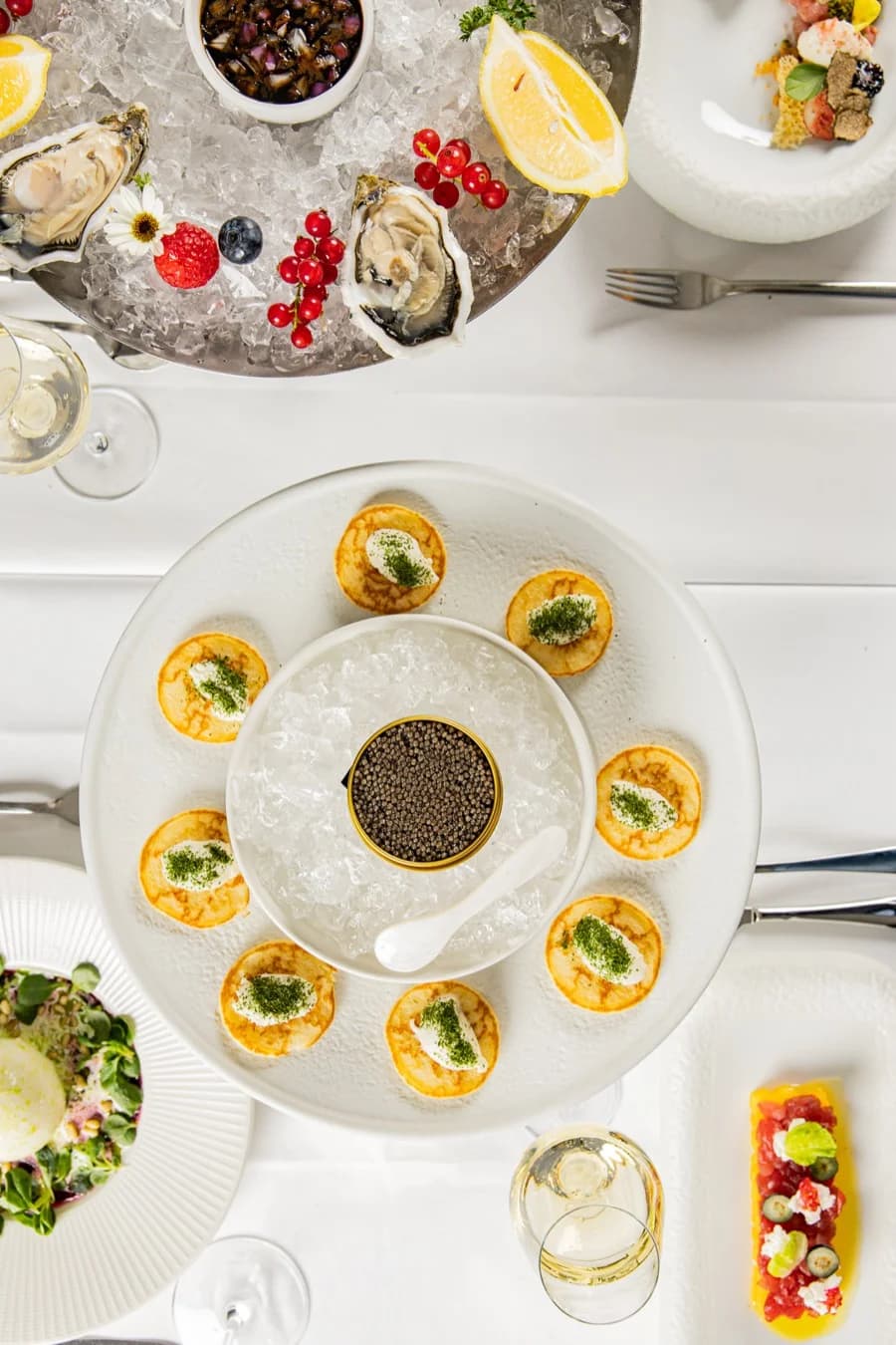 Kaviar mit Blinis und Austern auf Eis, von oben
