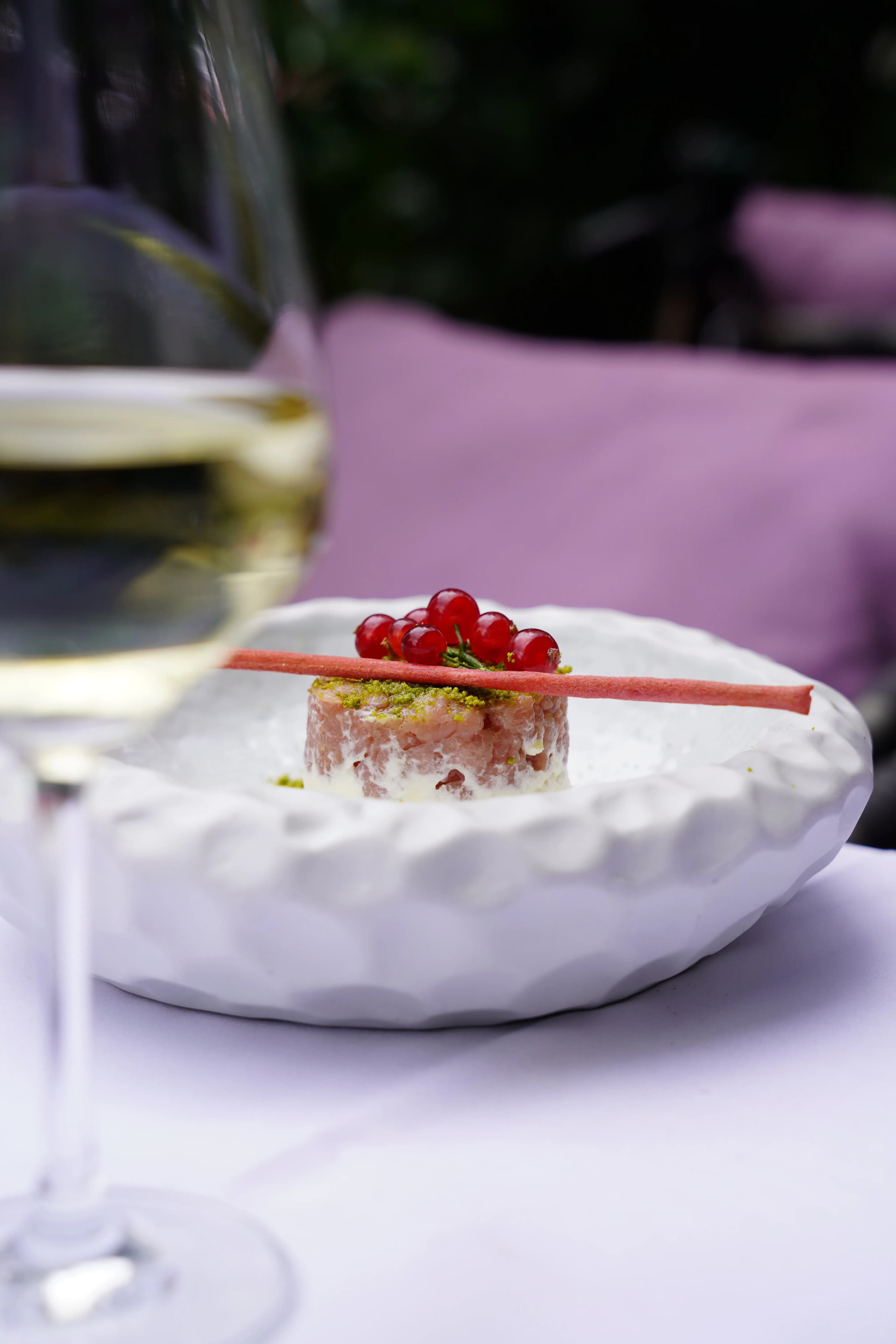 Bellucci Berlin – Dessert-Kreation mit roten Johannisbeeren und Pistazien-Krümeln im Sonnenlicht